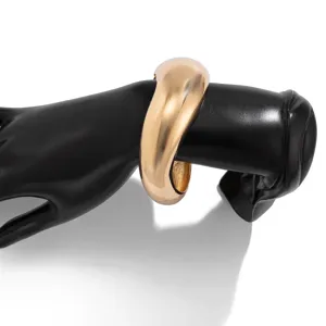 Detailweergave van een glanzende gouden waterdruppel armband gepresenteerd op een handmodel.