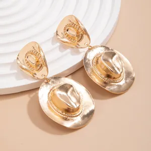 Close-up of retro gold-toned cowboy hat dangle earrings on display