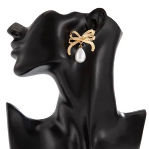 Detailansicht eines eleganten goldenen Schleifenohrrings mit weißer Perle auf einem Modell