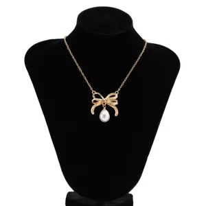 Elegante goldene Schleifen-Halskette mit Tropfenperle auf einer schwarzen Schmuckbüste