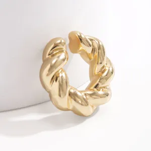 Vista dettagliata di un orecchino ear cuff a tortiglione dorato lucido con finitura a specchio.