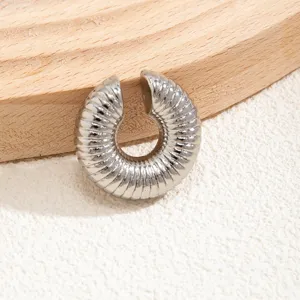 Dettaglio di un earcuff in argento a coste dal design circolare minimalista