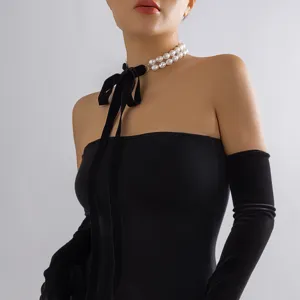 Elegant double-layered pearl choker necklace featuring a long black velvet bow ribbon detail