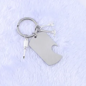 Close-up of stainless steel military tag bottle opener keychain with mini tool charms.