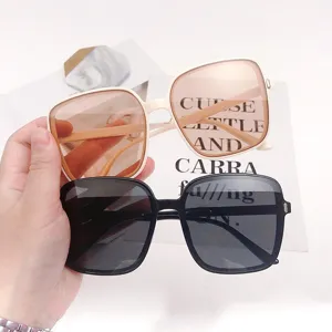Detail showing two pairs of oversized square sunglasses in beige and black frames