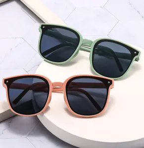 Detail shot of stylish folding UV-protective sunglasses in green and orange frames.