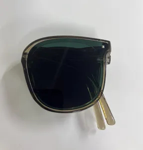 Foldable dark green sunglasses with translucent brown frames shown from top view
