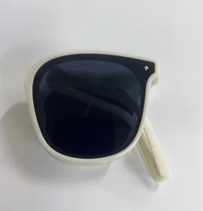 Close-up of foldable UV protection sunglasses in cream white frame showing compact design
