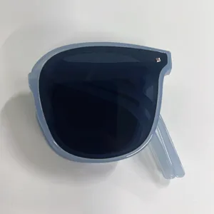 Detail view of stylish light blue foldable sunglasses with dark lenses in folded state
