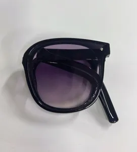 Close-up view of stylish black foldable sunglasses featuring purple gradient lenses