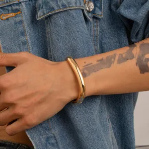 Detailansicht eines minimalistischen goldenen Herren-Manschettenarmband am Handgelenk