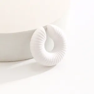 Vista dettagliata di un ear cuff bianco minimalista a coste con trama striata per orecchi