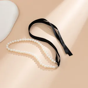 Detail view of vintage pearl choker necklace with adjustable black ribbon tie.