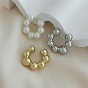Vista dettagliata di tre ear cuff con perline minimaliste in oro argento e finitura perla