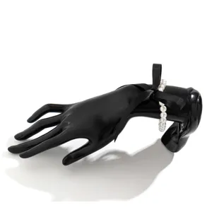 Detail view of the vintage black velvet ribbon pearl necklace on a mannequin hand.