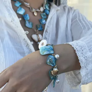 Detailansicht eines Ozean-Armbands mit blauen Muschelstücken und eleganten Perlenanhängern