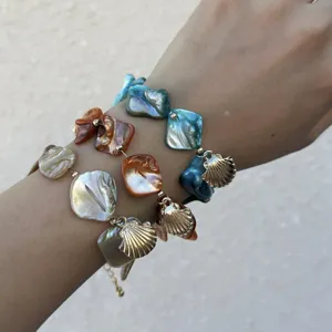 Detailansicht der unregelmäßigen Muschelarmbänder im Ozeanstil mit goldenen Anhängern
