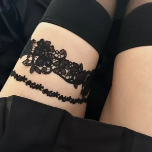 Close-up of a sexy black floral lace thigh chain garter belt for gothic fashion