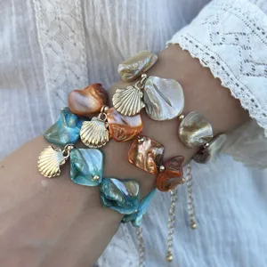 Nahaufnahme von unregelmäßigen Muschelarmbändern im Ozean-Stil an einem Handgelenk