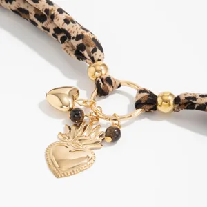 Detailed view of a vintage leopard print scarf necklace featuring golden sacred heart charms