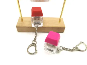 Macro detail view of mechanical keyboard switch fidget keychains in red and pink colors.