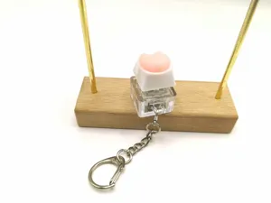 Close-up of pink soft silicone corgi butt keycap on a mechanical switch keychain