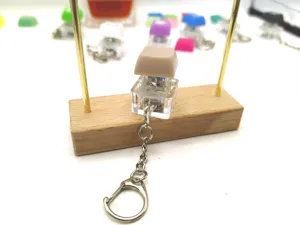 Detail view of transparent mechanical switch fidget keychain with a beige keycap set