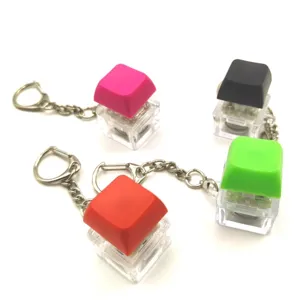 Close-up view of four colorful mechanical keyboard switch fidget keychains that glow