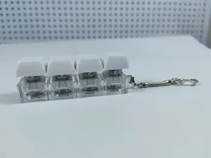 Portachiavi antistress con quattro tasti meccanici e copritasti bianchi su base trasparente