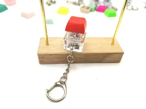 Close-up of a mechanical keyboard switch keychain with a vibrant red keycap design