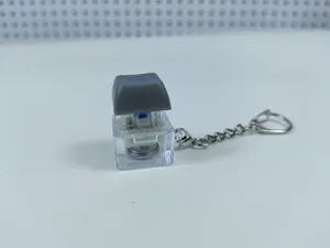 Transparent mechanical keyboard switch keychain with light-up stress relief fidget toy.