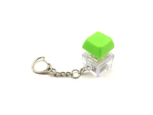 Close-up macro view of a glowing mechanical keyboard switch keychain with a vibrant green keycap