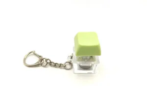 Close-up detail of a glowing mechanical keyboard keycap fidget toy keychain on white background