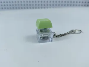 Close-up detail of the transparent mechanical keyboard keycap keychain with electronic light.