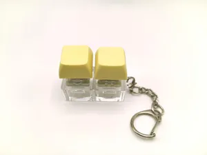 Cute mechanical keyboard switch keychain with dual yellow keycaps and portable metal ring.