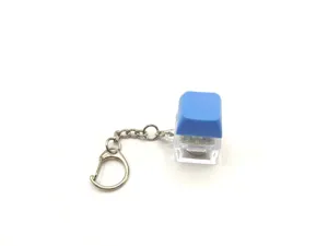 Detail view of a luminous mechanical keyboard keycap keychain with a blue cap