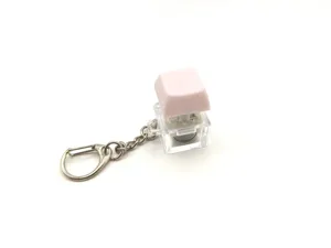 Detailed close-up of a pink mechanical keyboard switch keychain with transparent base