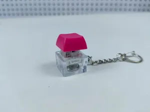 Detailed view of mechanical keyboard switch keychain, glowing fidget toy pendant