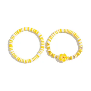 Detailansicht der gelb-weißen Heishi-Perlenarmbänder mit einem Plumeria-Blütenanhänger