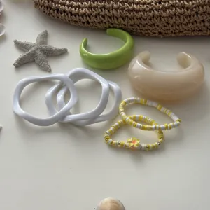 Detailansicht von Makronen-Resin-Armreifen und Perlenarmbändern mit Sommer-Deko