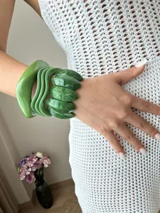 Nahaufnahme von grünen Harzarmreifen und marmorierten Armbändern am Handgelenk