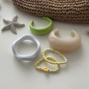 Buntes Macaron-Harz-Armreif-Set und Perlenarmbänder mit sommerlichen Strand-Accessoires.