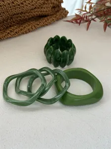 Detailansicht der grünen marmorierten Harzarmreifen und eines elastischen Armbands