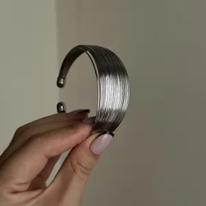 Primo piano di bracciale rigido multistrato in filo d'argento dal design lineare.