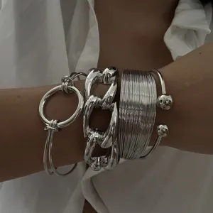 Primo piano dettagliato di bracciali rigidi argentati con linee minimaliste