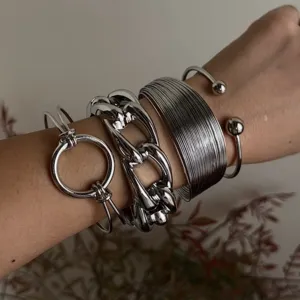 Dettaglio del set di bracciali a catena e cerchi in metallo argento stratificati