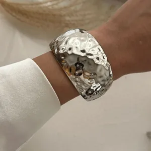 Nahaufnahme eines silbernen Armreifens mit gehämmerter Metallstruktur