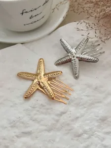 Detailansicht von goldenen und silbernen Seestern-Haarkämmen mit strukturierter Oberfläche.