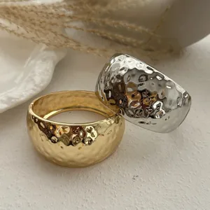Nahaufnahme von eleganten gold- und silberfarbenen breiten Armreifen mit Hammerschlag