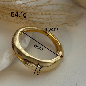 Detailansicht eines klobigen goldenen Armreifs mit Maßen und glatter Oberfläche